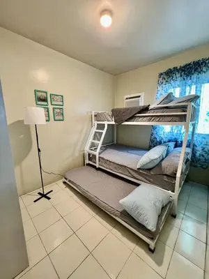 a bedroom with two bunk beds and a lamp at Jin's Jaunt in Manila