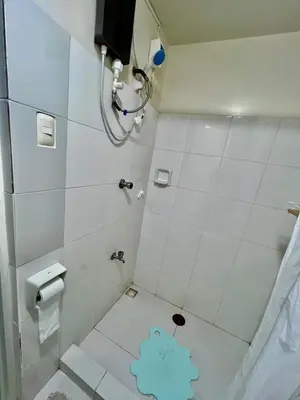 a bathroom with a shower with a blue bear on the floor at Jin's Jaunt in Manila