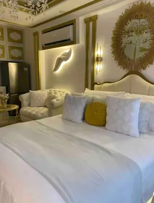 a bedroom with a large white bed with pillows at Royal Studio in Manila