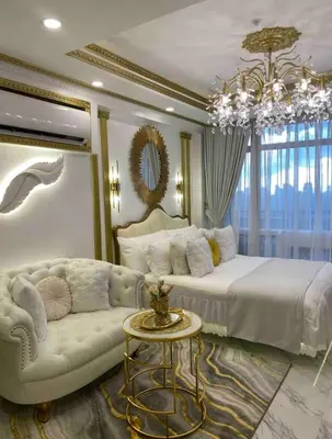 a bedroom with a bed and a couch and a chandelier at Royal Studio in Manila