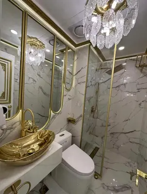 a bathroom with a gold sink and a toilet at Royal Studio in Manila