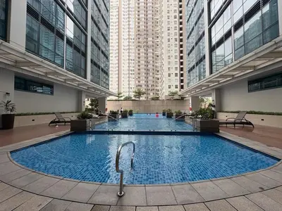 a large swimming pool in a building with tall buildings at Elegant BGC 1BR Staycation One Uptown Residence in Manila