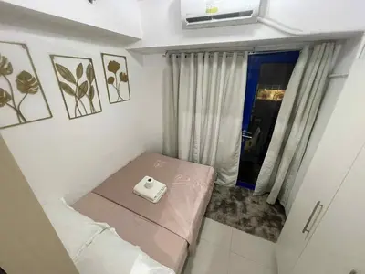 a small room with a bed and a window at Woodox Condotel in Manila