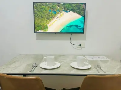 a table with two cups and a tv on a wall at Rooms near Aiport - Credit Card accepted 0995 - 448 - 8872 in Manila
