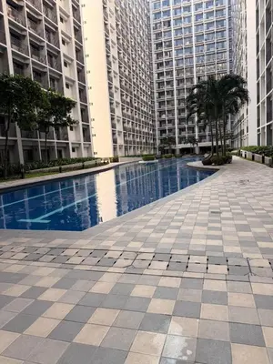 a swimming pool in the middle of two tall buildings at Modern Staycation near MOA & NAIA with PS4, Netflix, Wi-Fi in Manila
