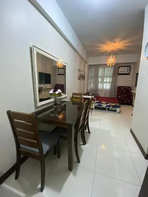 a dining room with a wooden table and chairs at Alliyah staycation newport101 near naia terminal 3 in Manila