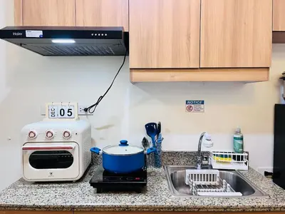a kitchen counter with a microwave and a sink at Chill Escape Prisma near BGC and Ortigas in Manila