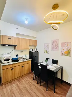 a kitchen with a table and a kitchen with a black refrigerator at Chill Escape Prisma near BGC and Ortigas in Manila