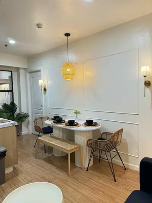 a living room with a table and chairs and a light at Transient Home by Molave in Manila