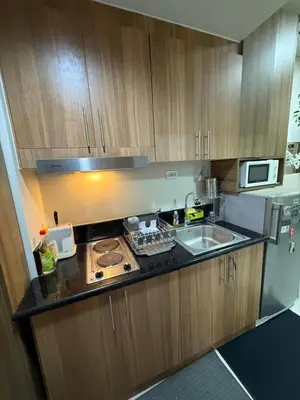 a small kitchen with a stove and a sink at Shore Bliss Staycation by Aims in Manila