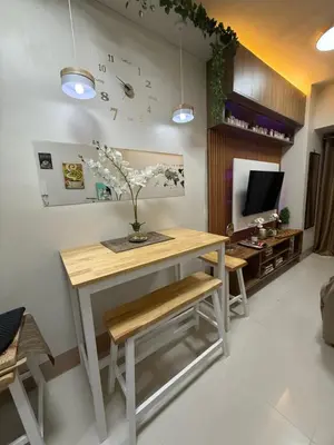 a room with a desk with a vase of flowers on it at Shore Bliss Staycation by Aims in Manila