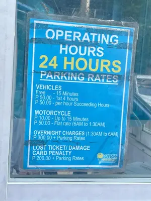 a sign in a window that says operating hours hours parking rates at Shore Bliss Staycation by Aims in Manila