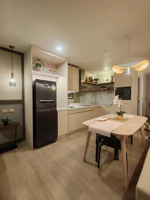 a kitchen with a table and a black refrigerator at InSpire Cozy Elegance in Makati City in Manila