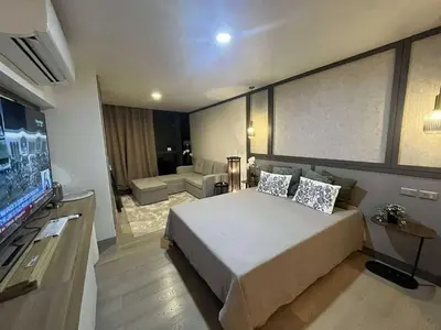 a bedroom with a large bed and a flat screen tv at InSpire Cozy Elegance in Makati City in Manila