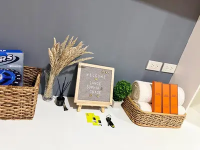 a table with baskets and a chalkboard and a chair at Affordable, Cozy & Quiet 1BR in BGC - Ideal for Short & Long Stays in Manila