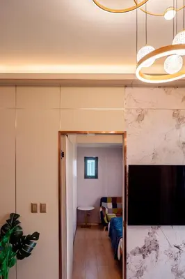 a room with a bed and a living room with a tv at Premium Condo units at Gentry Manor beside Okada Manila and near Airport in Manila