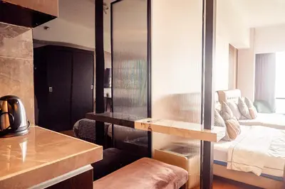 a bedroom with a bed with a glass wall at Elegant Condo at ETON Baypark Manila in Manila