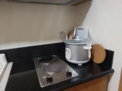 a kitchen counter with a stove and a slow cooker at Shore Residence 3 Mall of Asia by Balai Selah in Manila