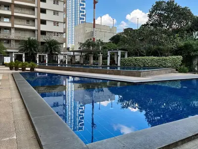 a swimming pool with blue water in a city at Stylish & Serene Penthouse in Manila