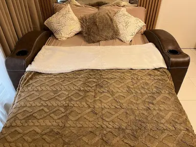 a bed with a blanket and pillows on it at Stylish & Serene Penthouse in Manila