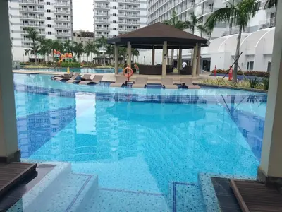 a large swimming pool with chairs and a gazebo at Shell Residences Condo in Manila