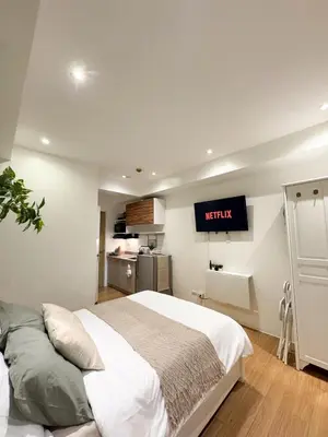 a bedroom with a king sized bed and a kitchen at Top-Floor Studio in Makati with City Views Good For 2-3 Pax in Manila