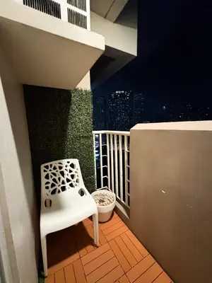 a white chair sitting on a balcony with a city skyline at Top-Floor Studio in Makati with City Views Good For 2-3 Pax in Manila