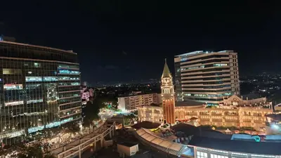 a city skyline at night with a clock tower at Venice Condotel in Manila