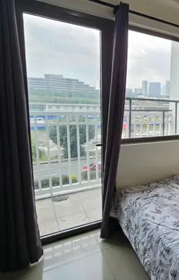 a bedroom with a window with a view of a city at Mall of Asia Staycation, located in Shore Residences Pasay Manila near Manila Airport in Manila