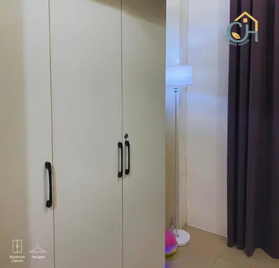 a room with two white cabinets and a lamp at Mall of Asia Staycation, located in Shore Residences Pasay Manila near Manila Airport in Manila