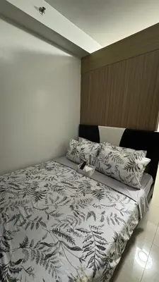 a bedroom with a bed with a black and white comforter at Pasay Manila Condominium Rentals, walking distance to Mall of Asia and near in Manila airport, located in Shore Residences Seaside Boulevard in Manila