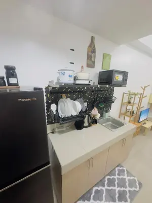 a kitchen with a sink and a black refrigerator at Ellain's Cozy Staycation-SMDC Green 2 Residences in Dasmariñas