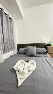 a bed with towels in the shape of a heart at Ellain's Cozy Staycation-SMDC Green 2 Residences in Dasmariñas