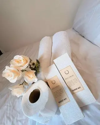 a bed with towels and a cup of coffee and flowers at Condo with Sunset View in Manila