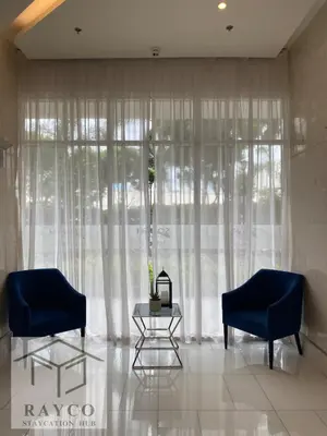 a living room with two blue chairs and a table at Condo with Sunset View in Manila