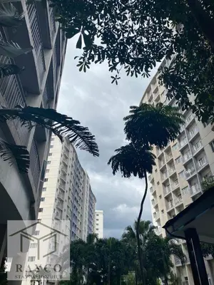 two tall buildings in a city with palm trees at Cozy Escape with Golden Hour View Condo in Manila