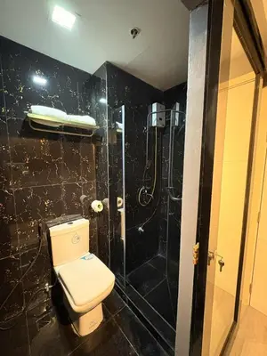 a bathroom with a toilet and a shower at Cozy Escape with Golden Hour View Condo in Manila