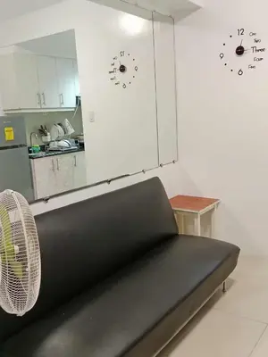 a black couch in a room with a kitchen at Sea Residences Golden escape condotel in Manila