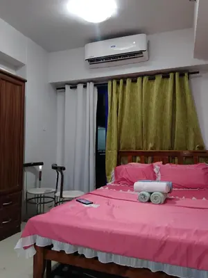 a bedroom with a pink bed with a pink blanket at Sea Residences Golden escape condotel in Manila