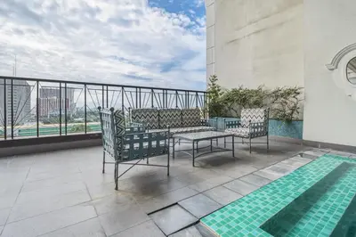 a balcony with a table and chairs and a pool at Admiral Baysuites 2602 in Manila