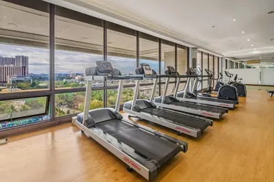 a gym with a row of treadmills and ellipticals at Admiral Baysuites 2602 in Manila