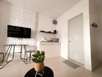 a living room with a television and a plant in it at BES Building in Dasmariñas
