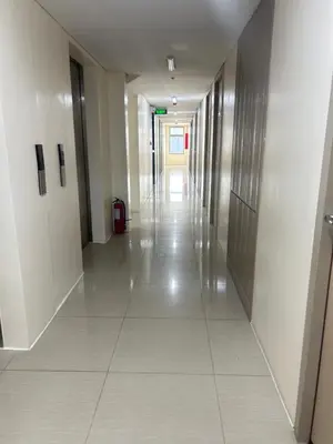 an empty hallway in a building with white tile floors at UDCT Condo Hotel in Manila in Manila