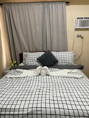 two twin beds in a bedroom with a window at Affordable 1BR Condo In Pasay with Balcony and Amenity View, Free Pool Fast WiFi Near NAIA Airport , MOA,PICC in Manila