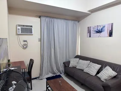 a living room with a couch and a table at Affordable 1BR Condo In Pasay with Balcony and Amenity View, Free Pool Fast WiFi Near NAIA Airport , MOA,PICC in Manila