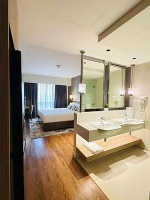 a large bathroom with a bed and a sink at Hotel Residence Acqua - Novotel Suites in Manila