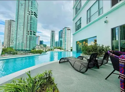 a balcony with chairs and a swimming pool in a city at Hotel Residence Acqua - Novotel Suites in Manila