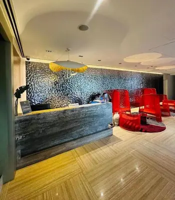 a lobby with red chairs and a bar with a wall at Hotel Residence Acqua - Novotel Suites in Manila