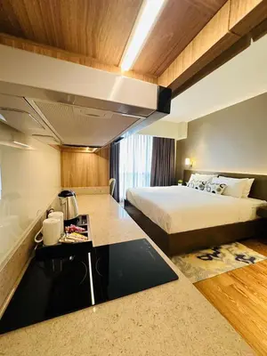 a hotel room with a bed and a table at Hotel Residence Acqua - Novotel Suites in Manila