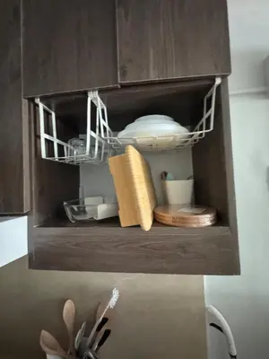 a cupboard with dishes and utensils in it at Just for sleeps in Manila